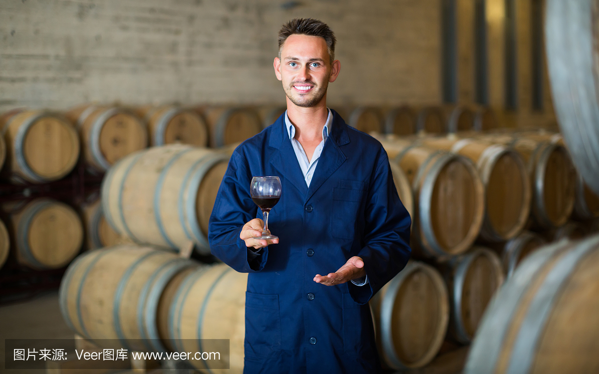 酒莊員工拿著裝在玻璃杯里的葡萄酒樣品